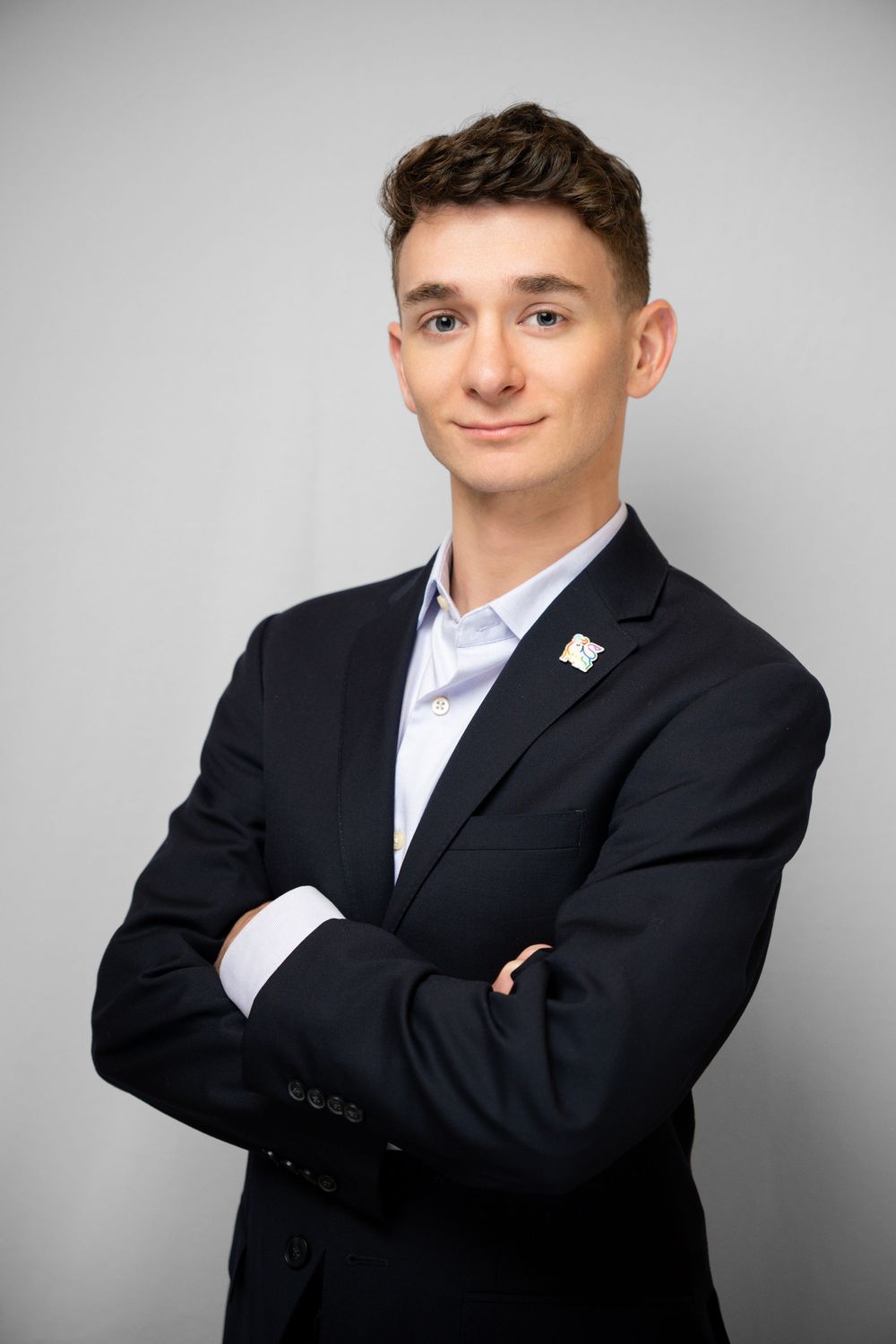 Professional studio portrait series showing a subject in a black suit and white shirt against a light gray background.