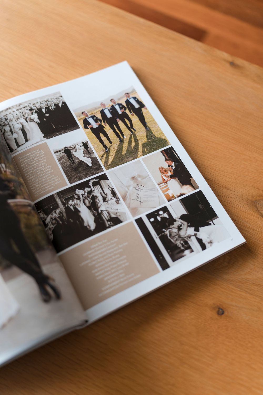 Open wedding photo book on wooden surface displaying multiple photographs and text layouts.