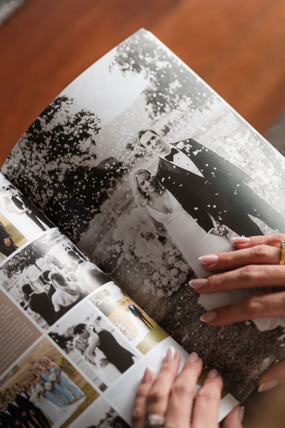 Hands turn pages of a vintage black and white wedding photo album displaying classic marriage photographs.