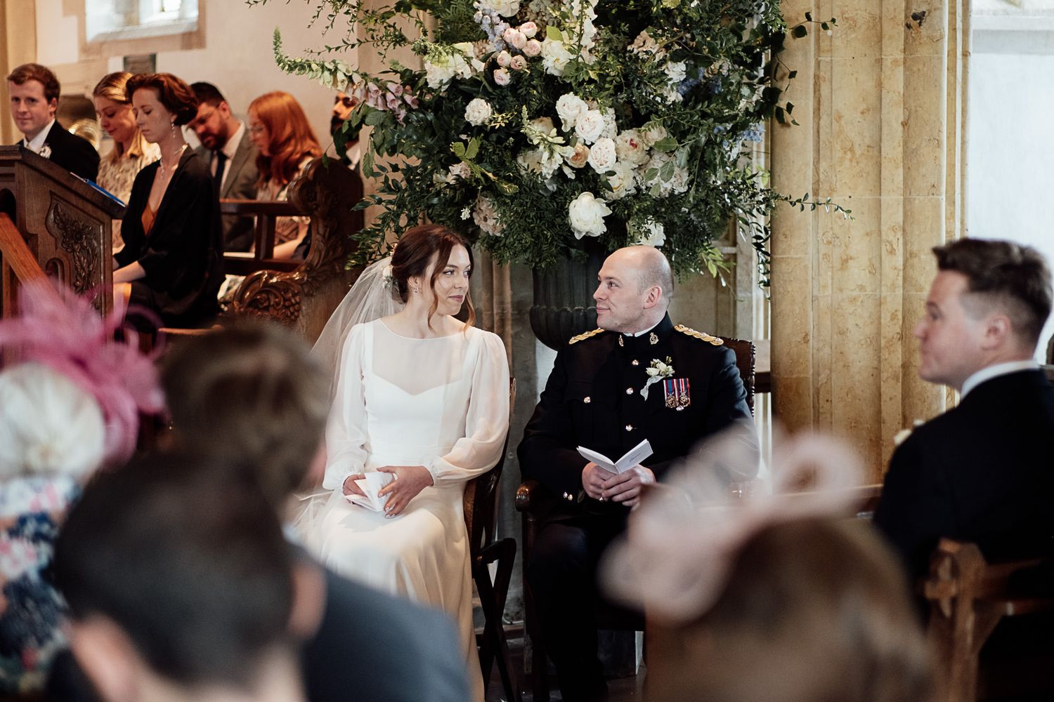 Wedding guests inside a rustic wooden barn venue raise their glasses during a celebration toast.