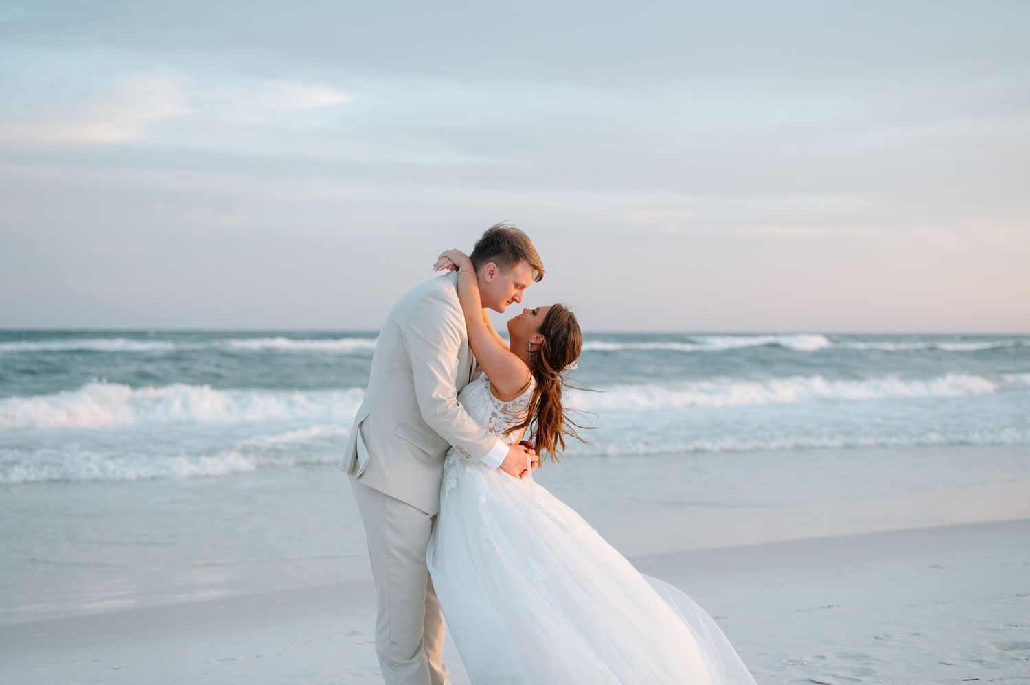 Newlyweds embracing during golden hour at a Pensacola Beach Florida wedding, photographed by Emily Barrett Photo.