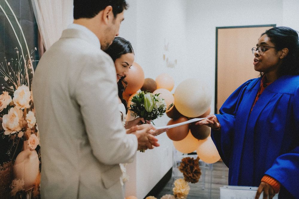 A couple receives their marriage certificate from an officiant during an intimate ceremony.