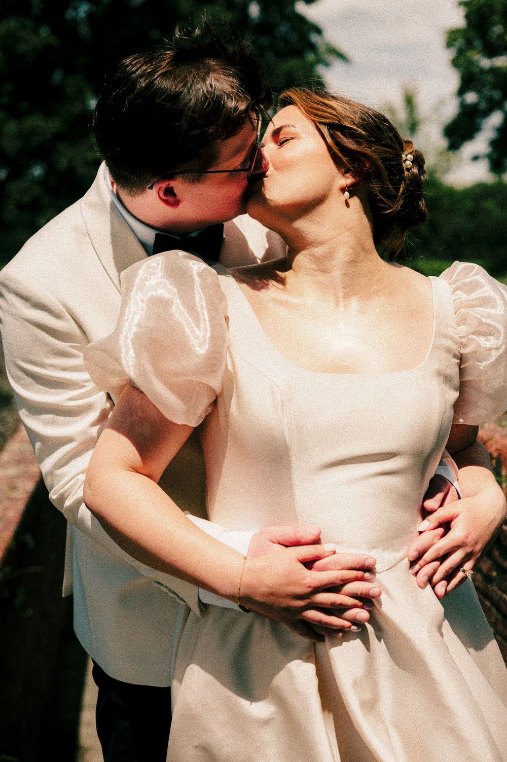 A romantic wedding moment captured in natural light with white attire.