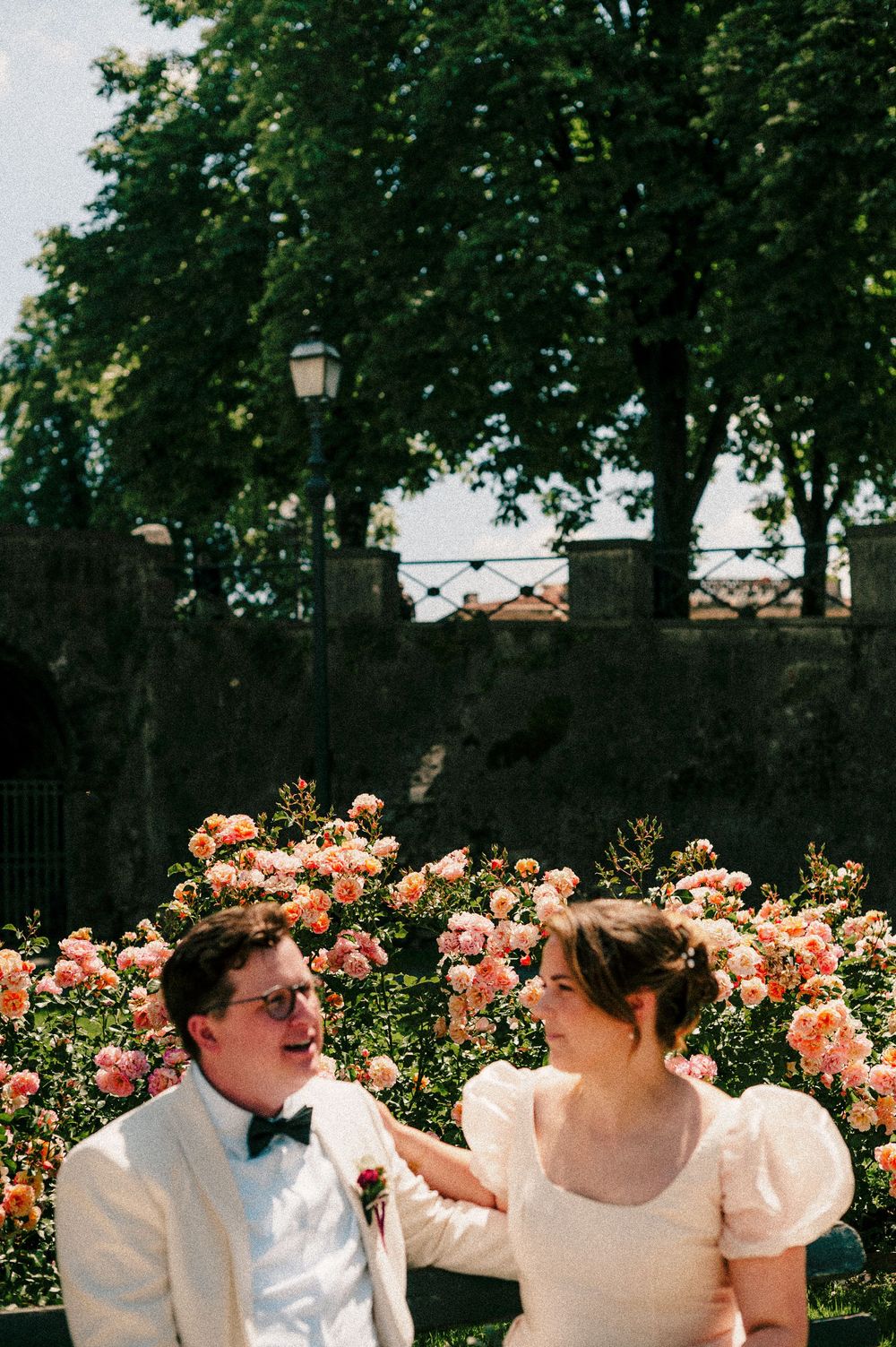 A joyful moment shared between newlyweds in a rose garden.