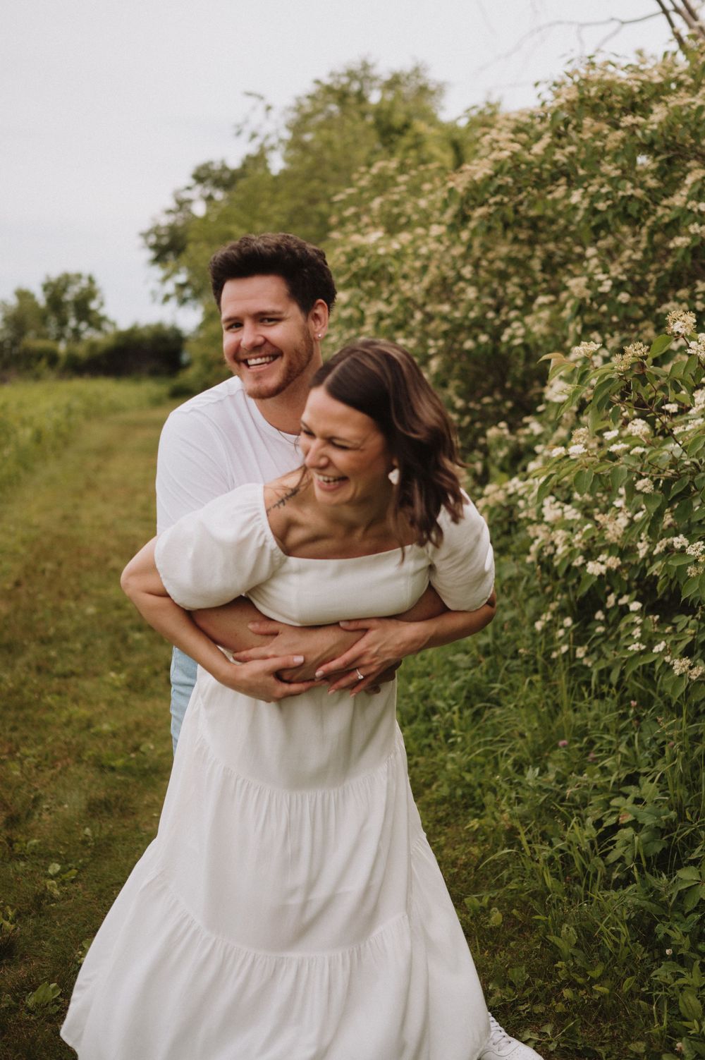 A heartwarming embrace captured between a couple on a flowering spring trail.
