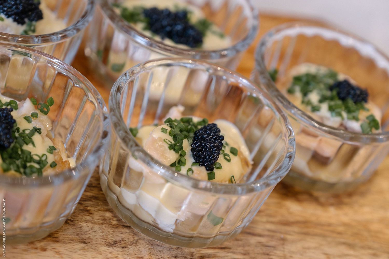 Small glass bowls filled with creamy appetizer topped with fresh broccoli.