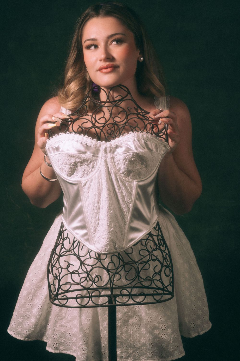Fashion portrait featuring white dress with decorative wire overlay design.