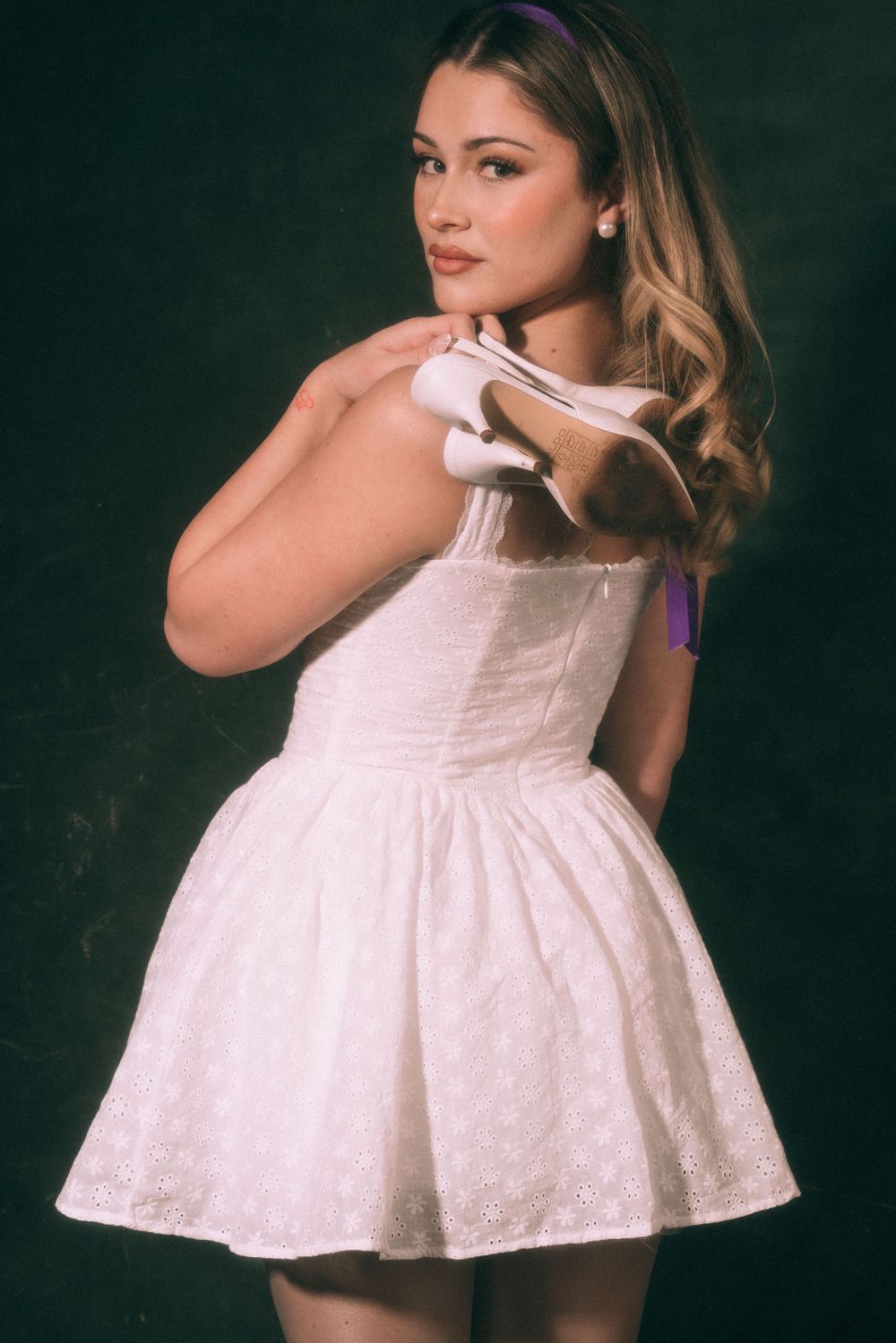 Classic portrait style photo featuring white summer dress against dark background.