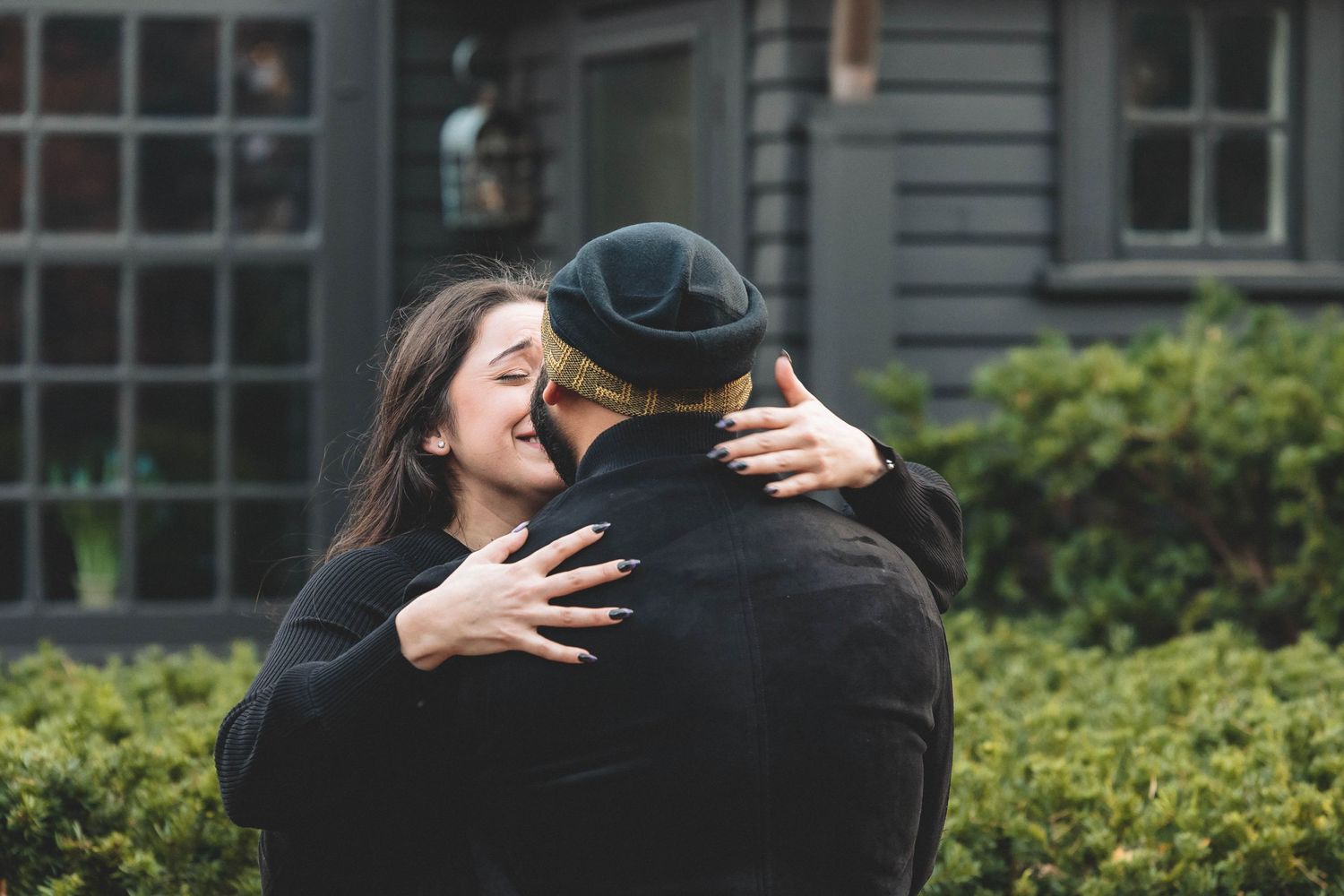 An emotional embrace captured between two people wearing dark clothing.