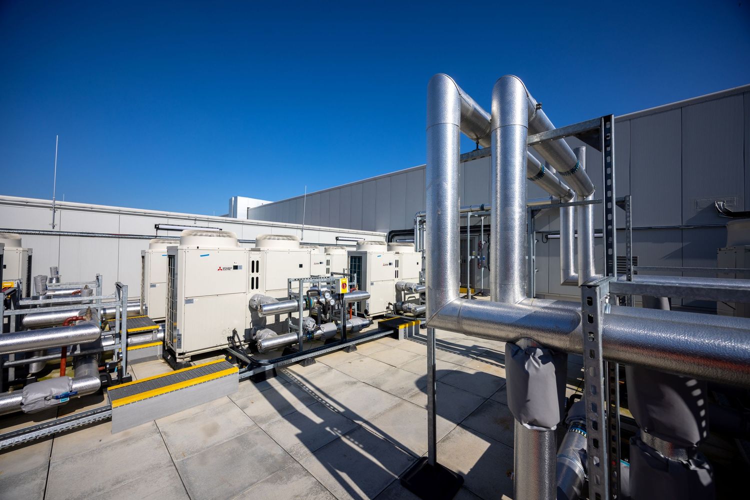 Outdoor industrial equipment area with silver pipes and mechanical systems.