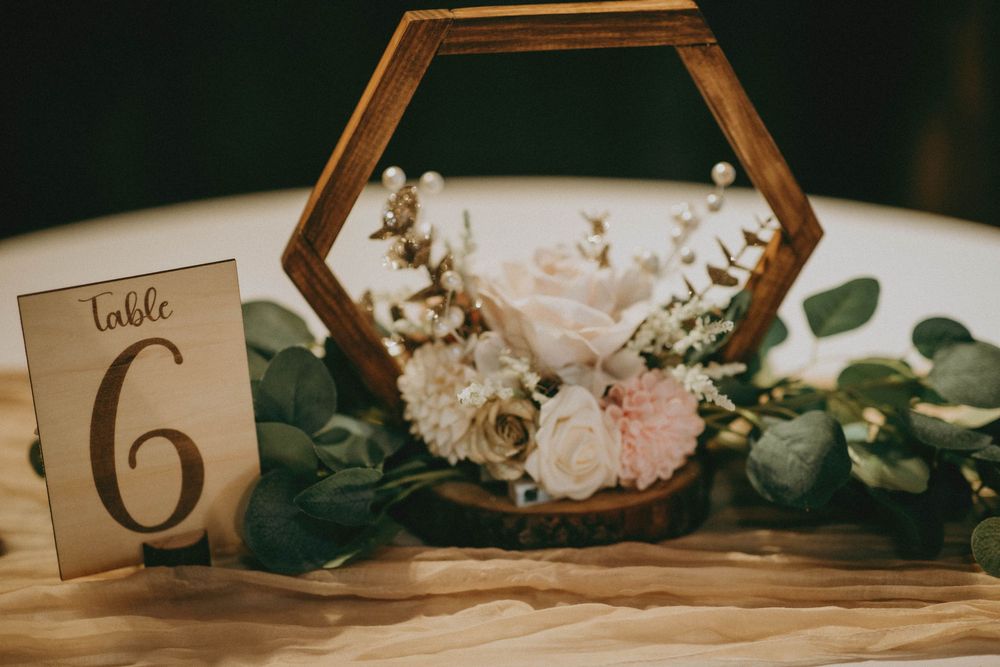 Elegant wedding reception table decor with greenery garlands, geometric accents, and rustic number cards.