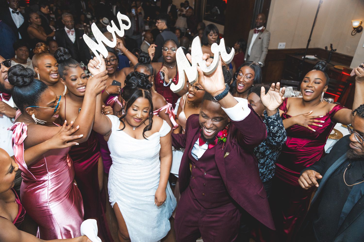Wedding reception dance floor filled with celebrating guests in formal attire.
