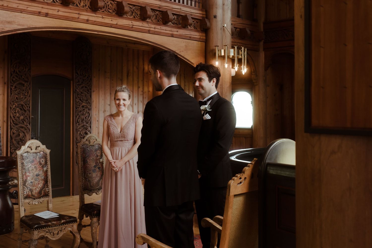 A wedding ceremony in progress inside an ornate historic venue with dramatic lighting.