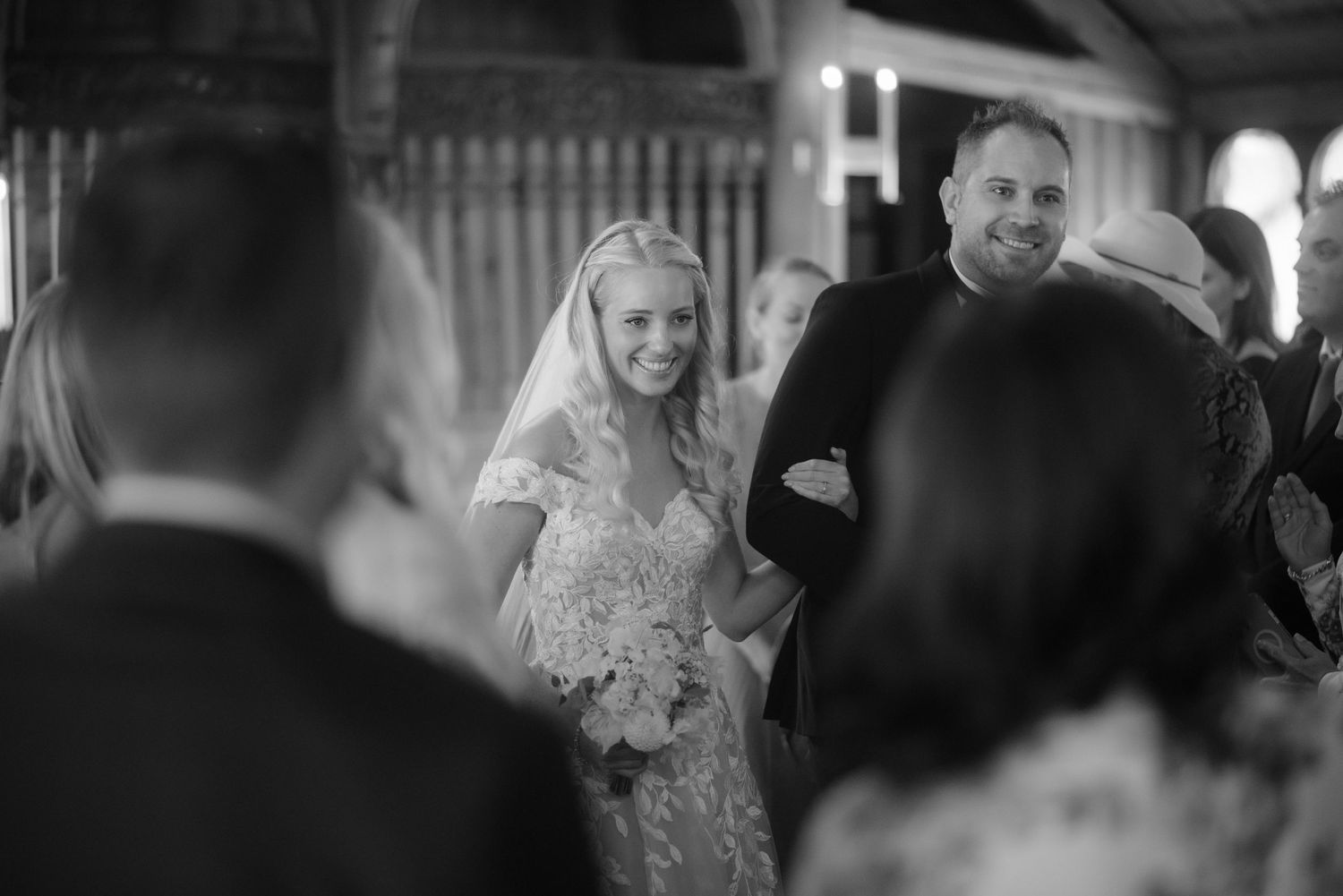 A joyful wedding ceremony moment captured in black and white as the couple walks down the aisle.