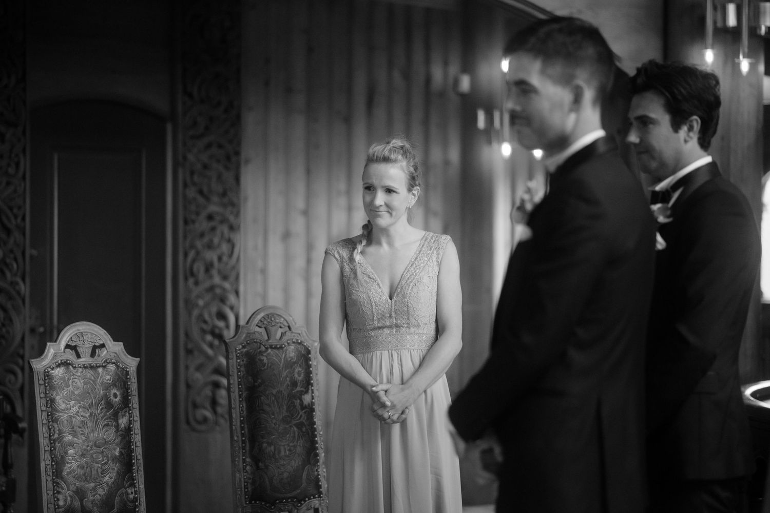 Elegant wedding ceremony in a grand room with ornate carved chairs and decorative walls.