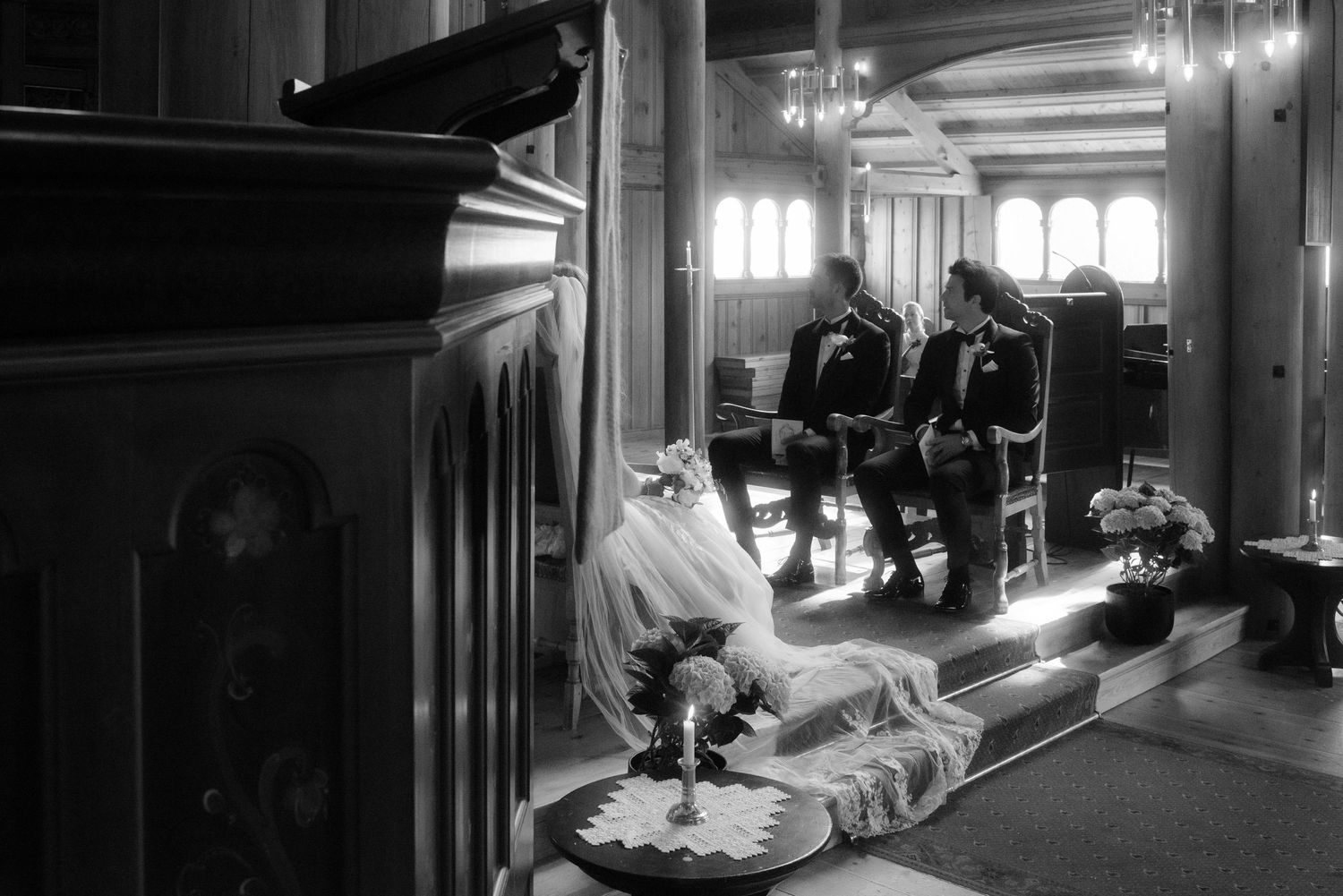 Black and white image of wedding preparations in an ornate hallway.
