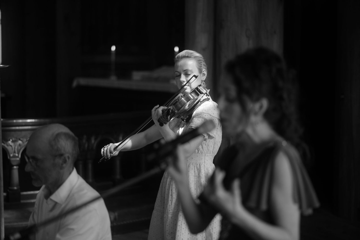 Musicians perform with violin during an intimate church wedding service.