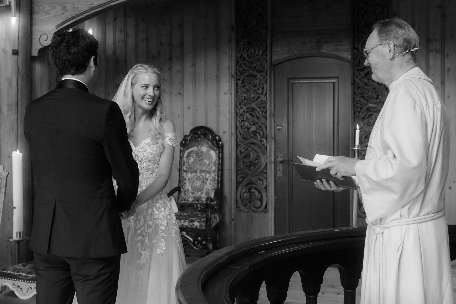 Black and white photograph of a wedding ceremony in an elegant vintage interior.