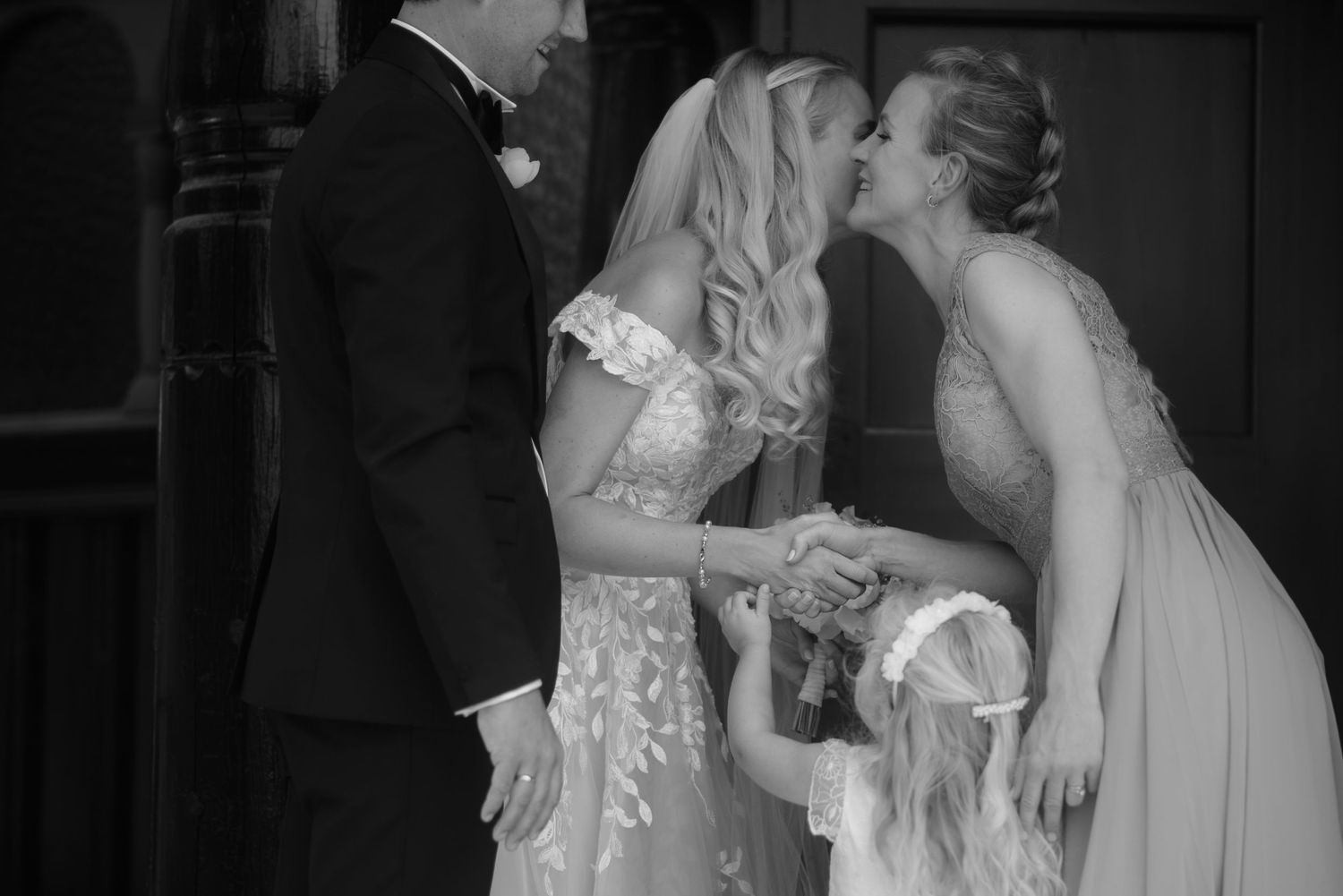 Black and white candid moment of wedding couple sharing an intimate moment during ceremony.