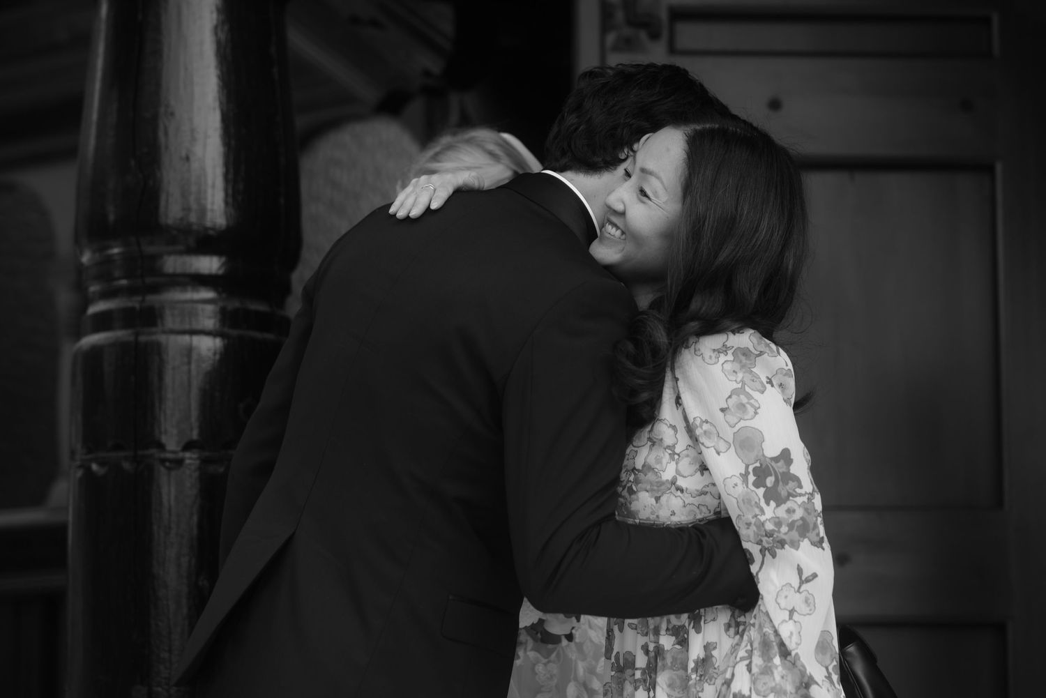 Black and white emotional embrace captured during wedding celebration.