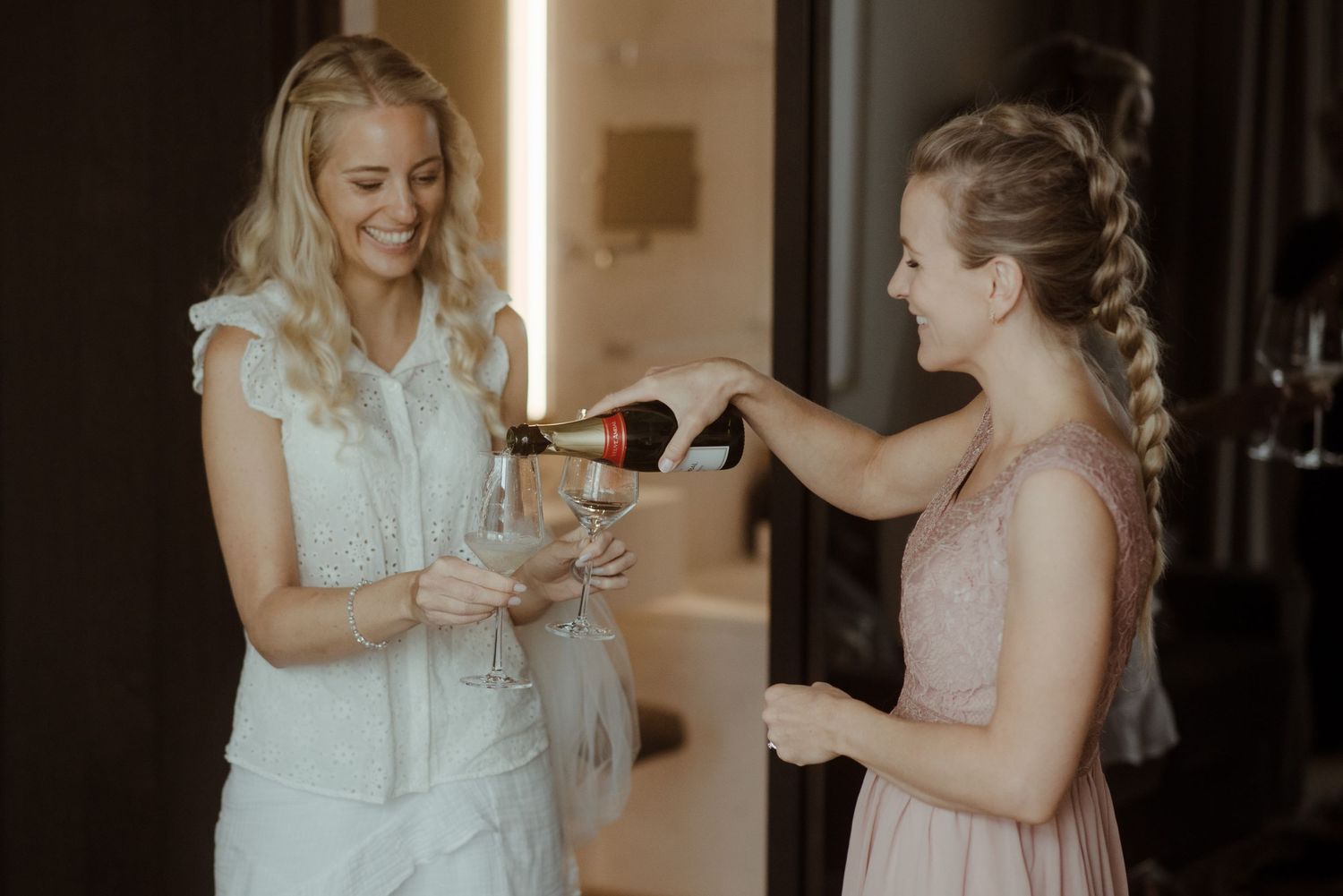 Bridesmaid helping with makeup preparations before the wedding ceremony.