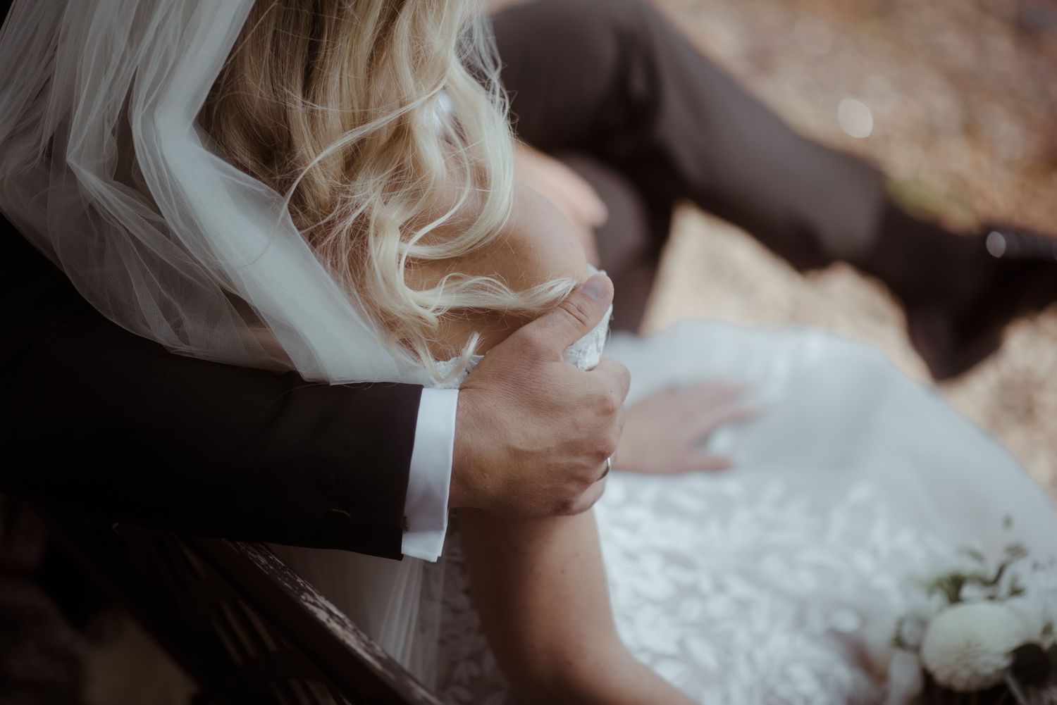 Close-up shot of wedding dress details with veil and formal attire.
