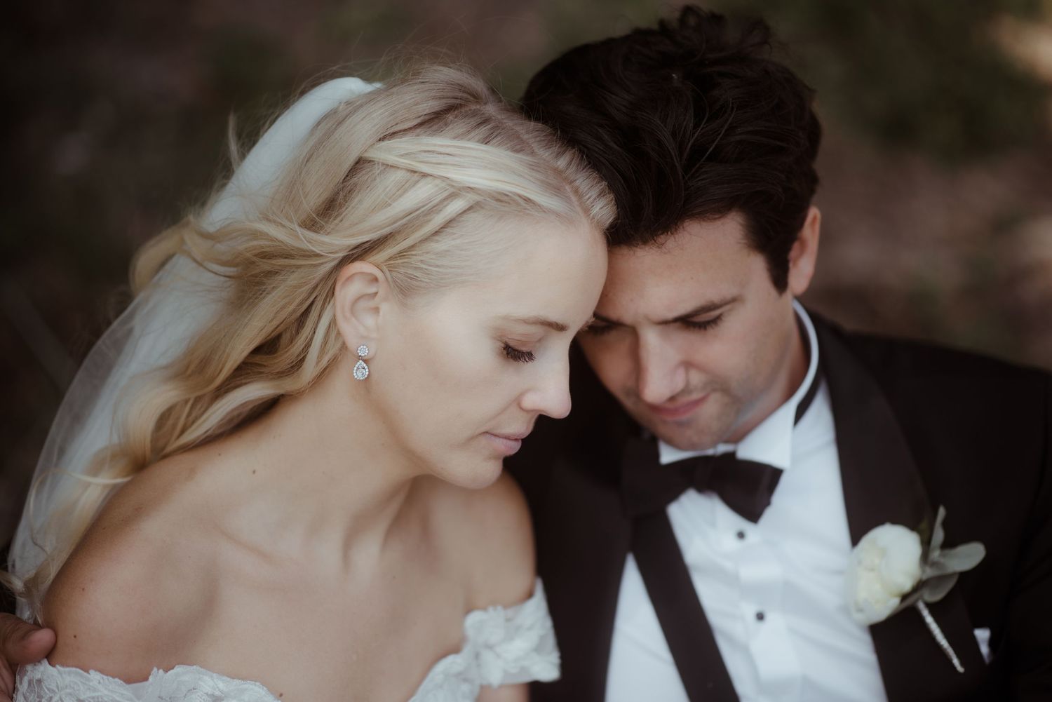 An intimate moment between newlyweds in formal wedding attire.