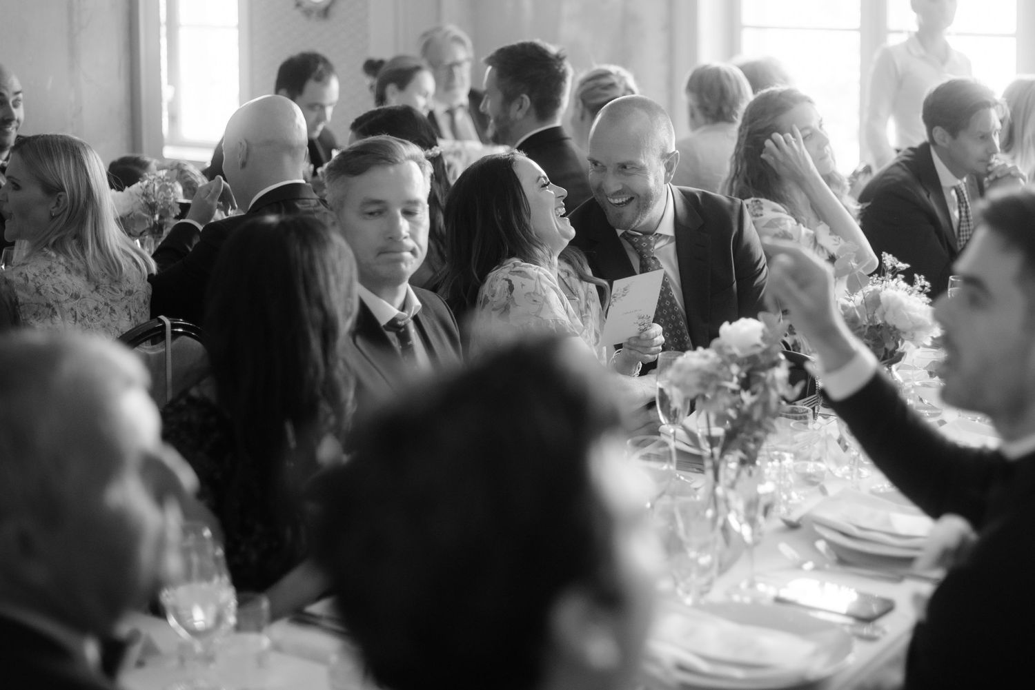 Black and white image of guests dining at an elegant reception.