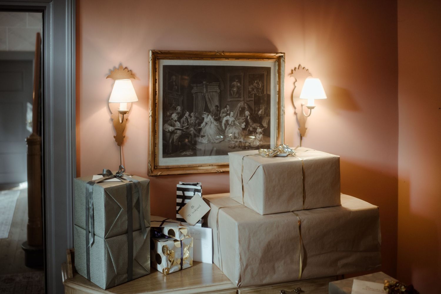 Wedding gifts wrapped in white paper displayed on a marble table with vintage lamps.