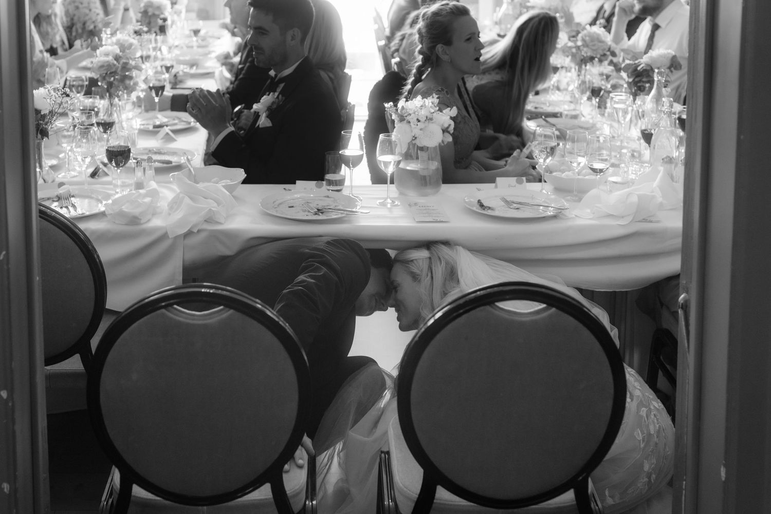 Black and white photo of formal table settings at an elegant banquet.