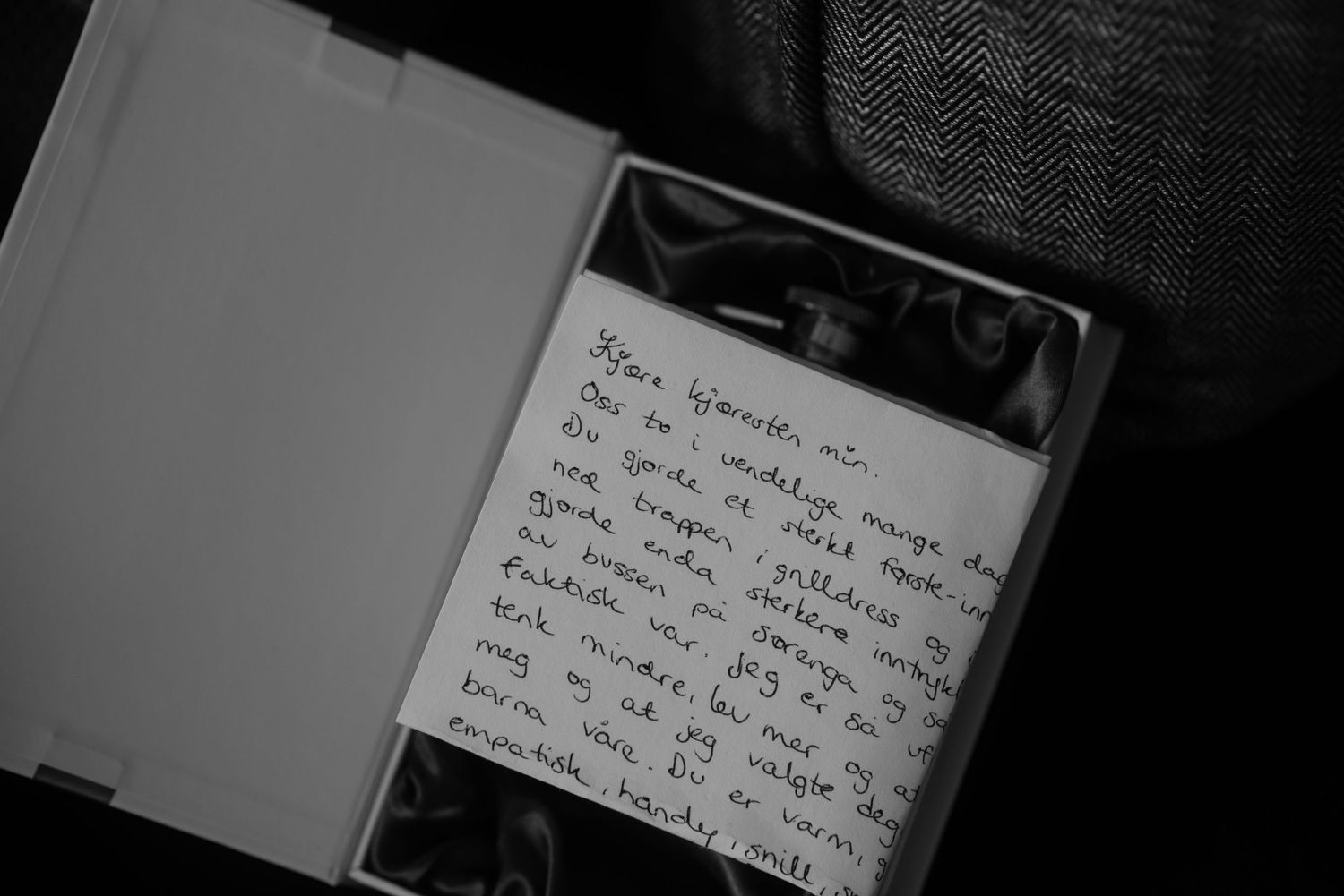 A handwritten note in black ink on white paper captured in moody lighting.