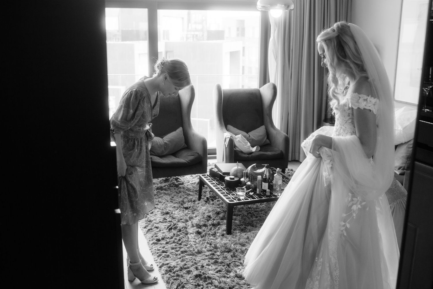 A candid moment of wedding preparation in a hotel room with elegant decor.
