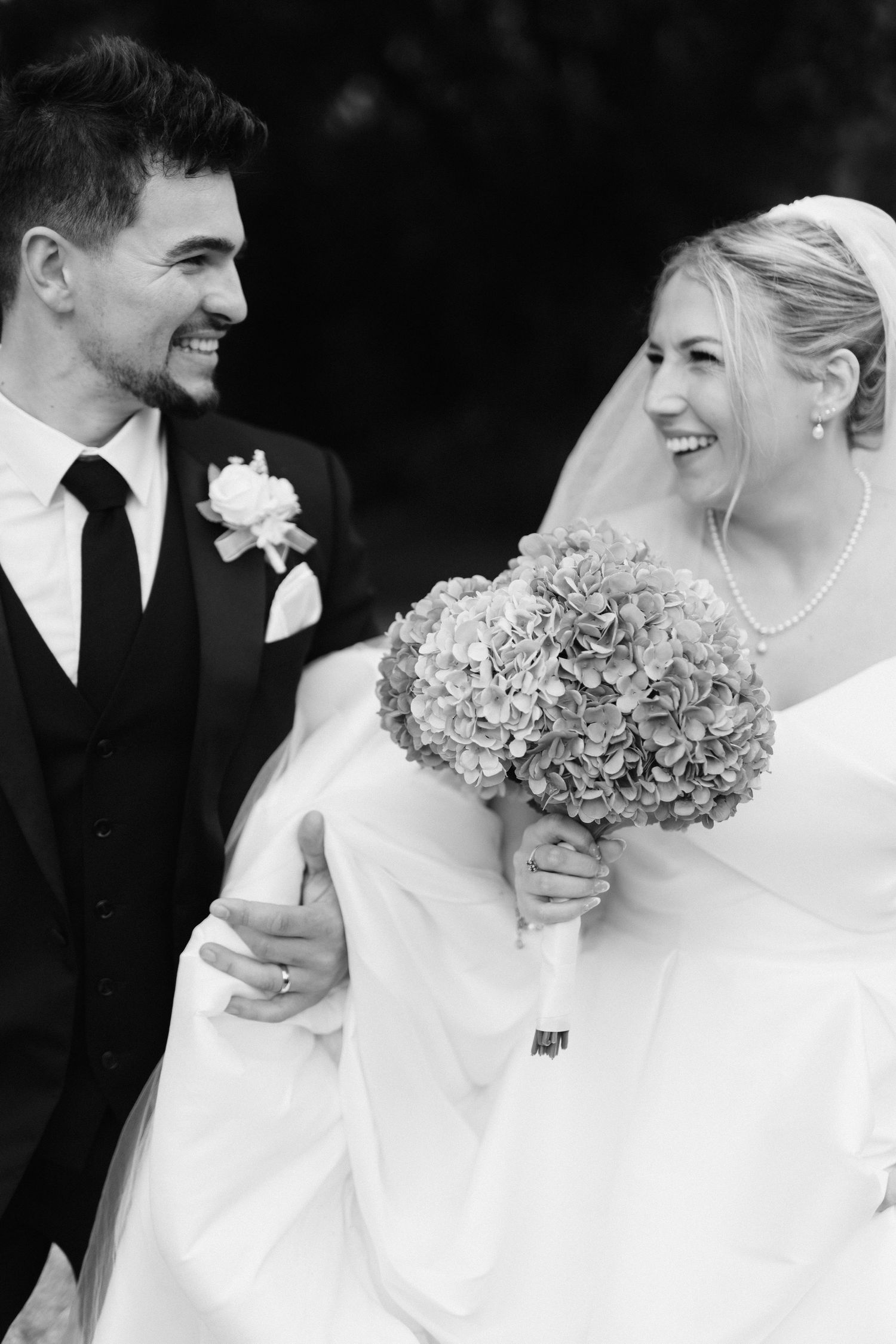 A joyful wedding moment captured in black and white with beautiful hydrangea bouquet.