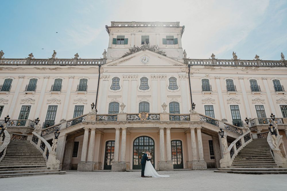Grand white neoclassical mansion with symmetrical double staircases flanking an elegant arched entrance.