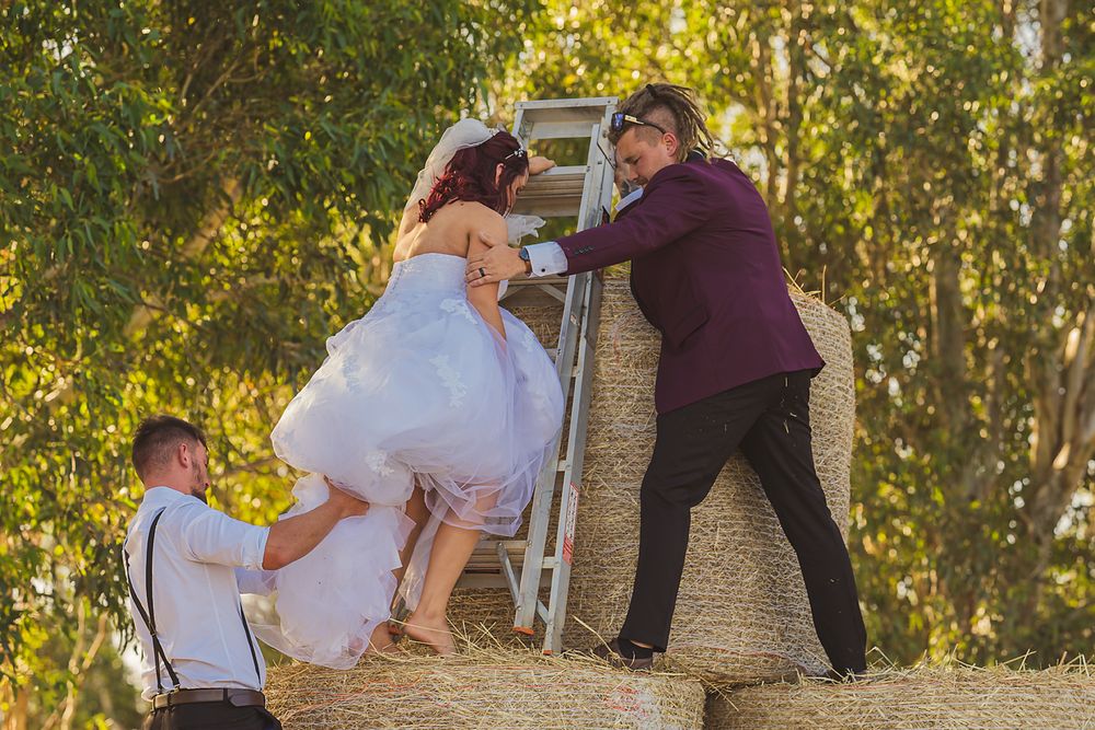 A romantic outdoor fall wedding ceremony features a couple embracing under golden sunlit trees.