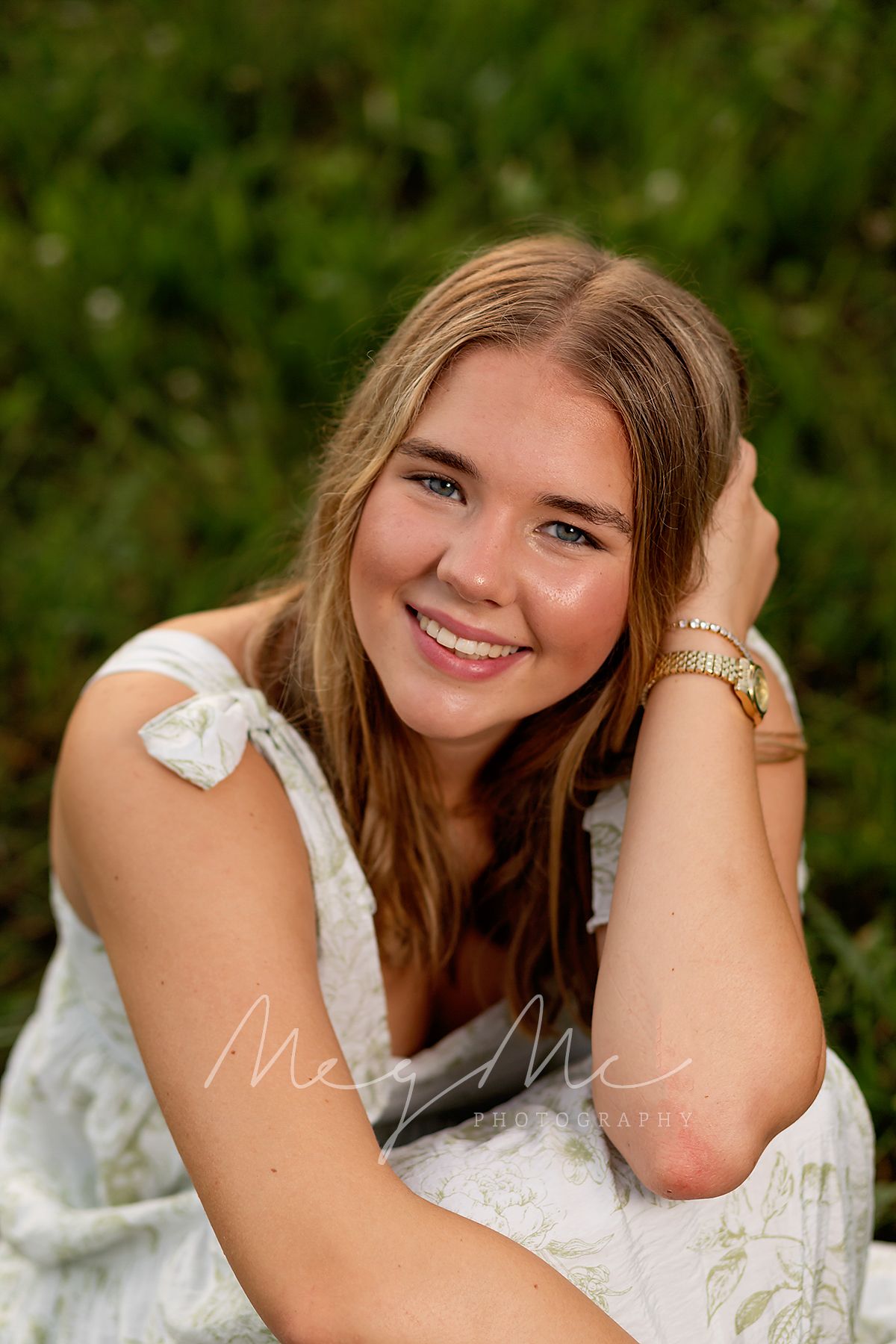A relaxed senior photo shoot in a green summer field at golden hour captured by MegMc Photography, Medina, TN