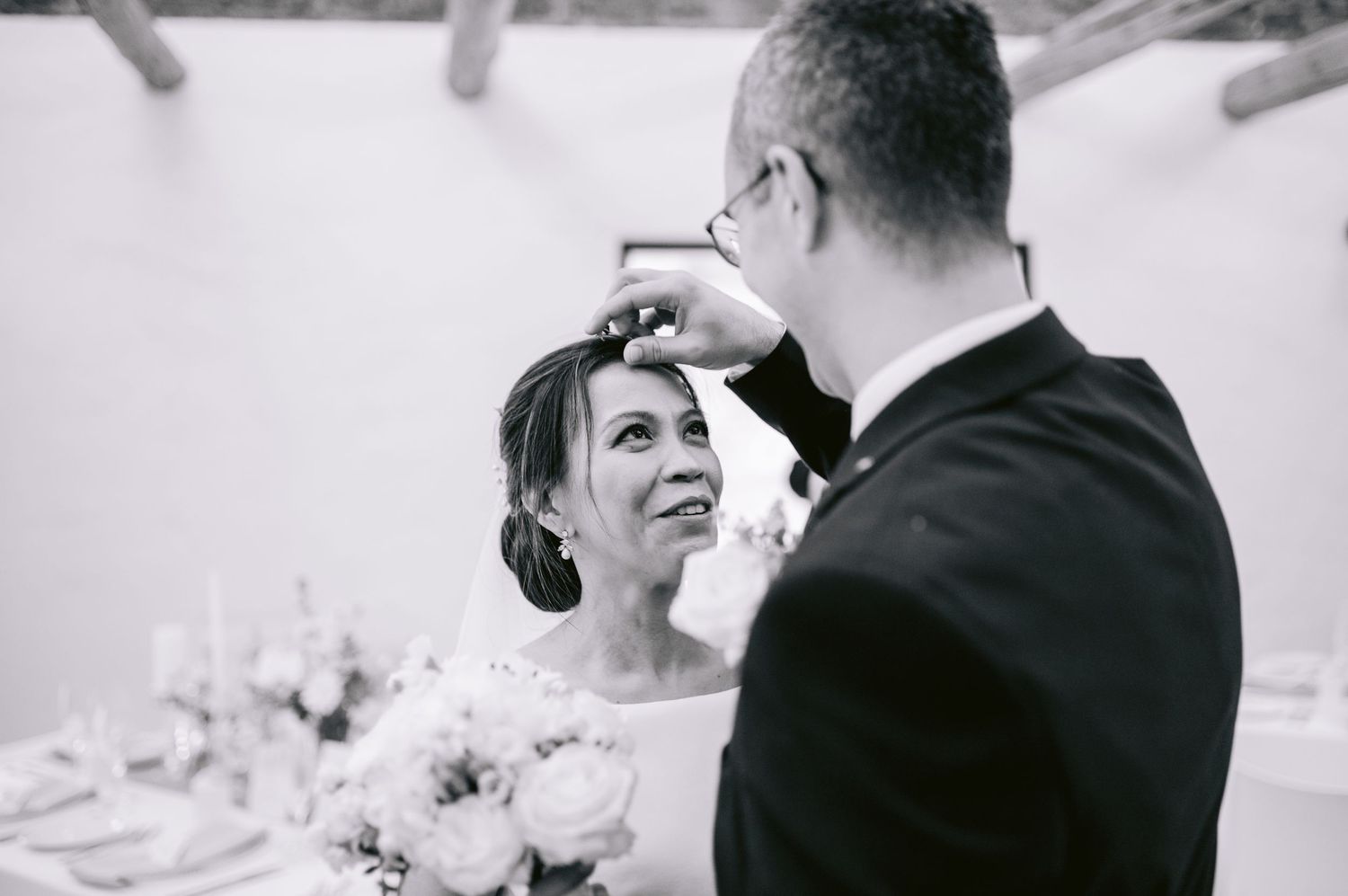 A wedding couple shares four intimate black and white moments during their celebration, captured in romantic candid poses.