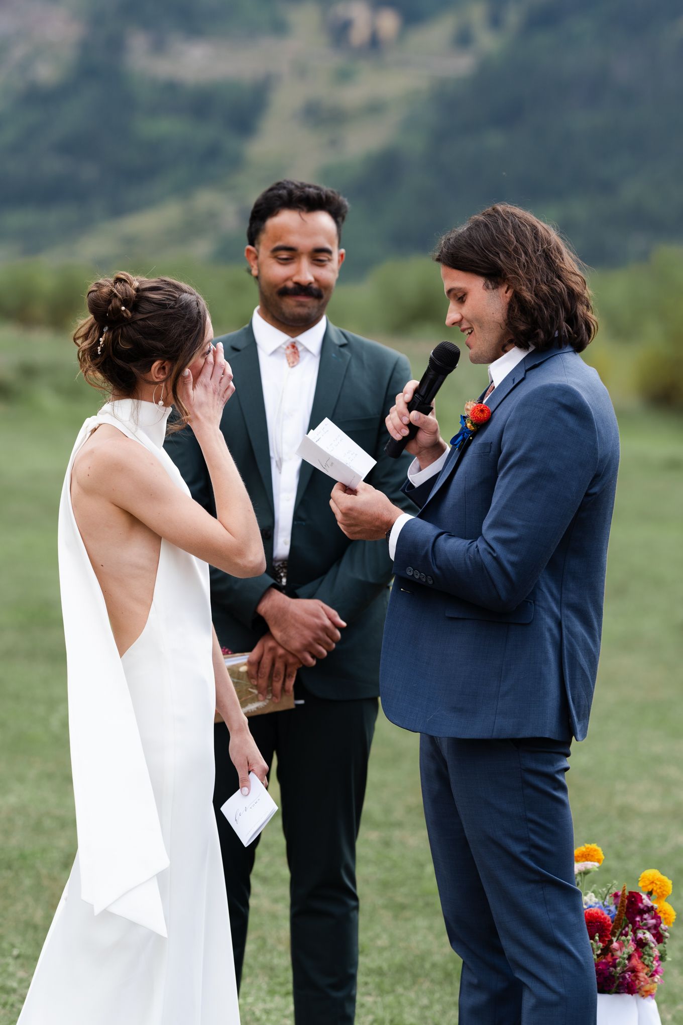 Emotional wedding ceremony with couple and officiant sharing intimate moment in mountain setting.