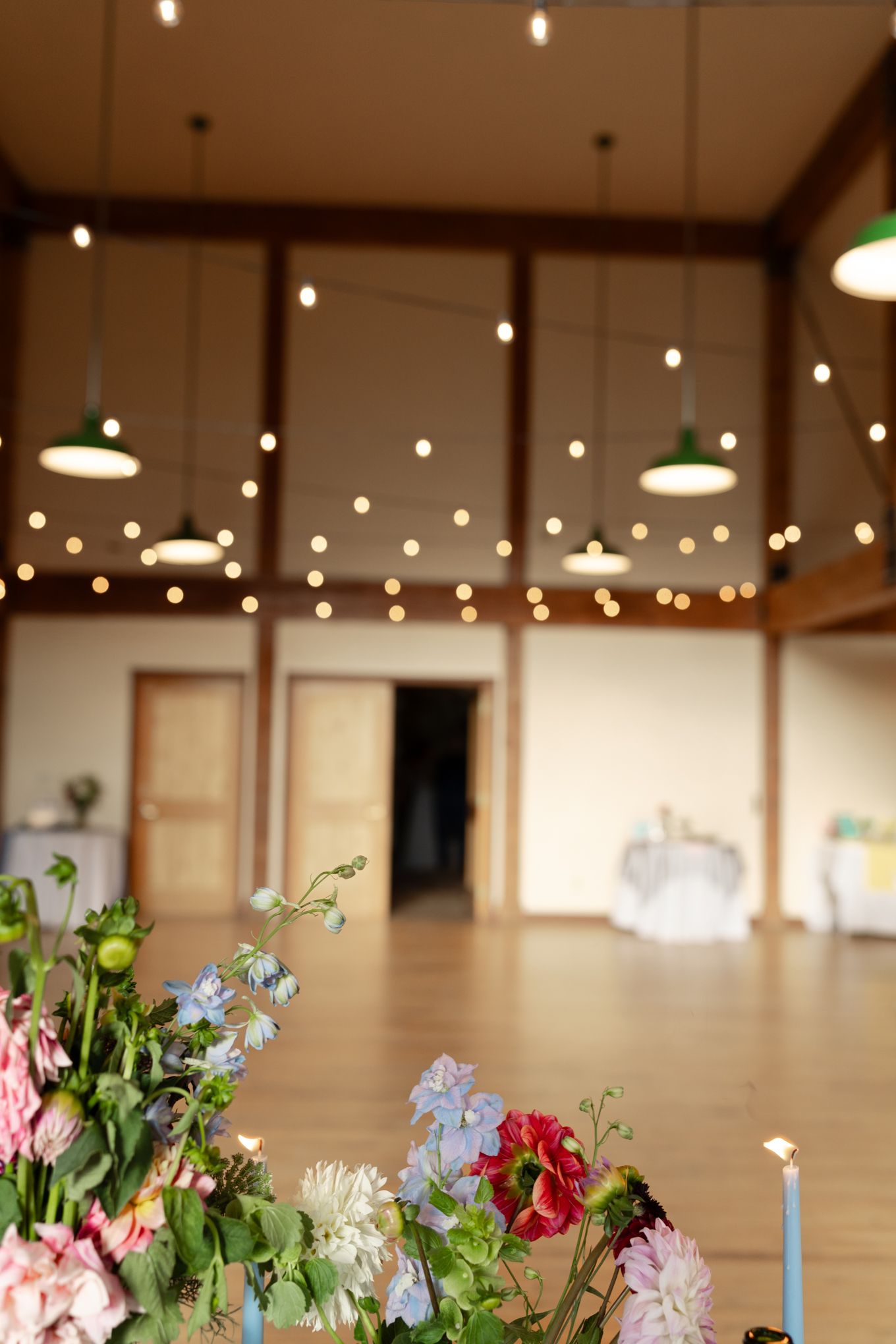 Elegant venue space with hanging pendant lights and fresh floral arrangements creating a warm ambiance.
