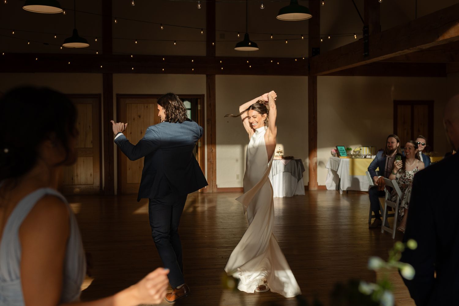Couple dancing in an elegant venue with string lights creating a romantic atmosphere.