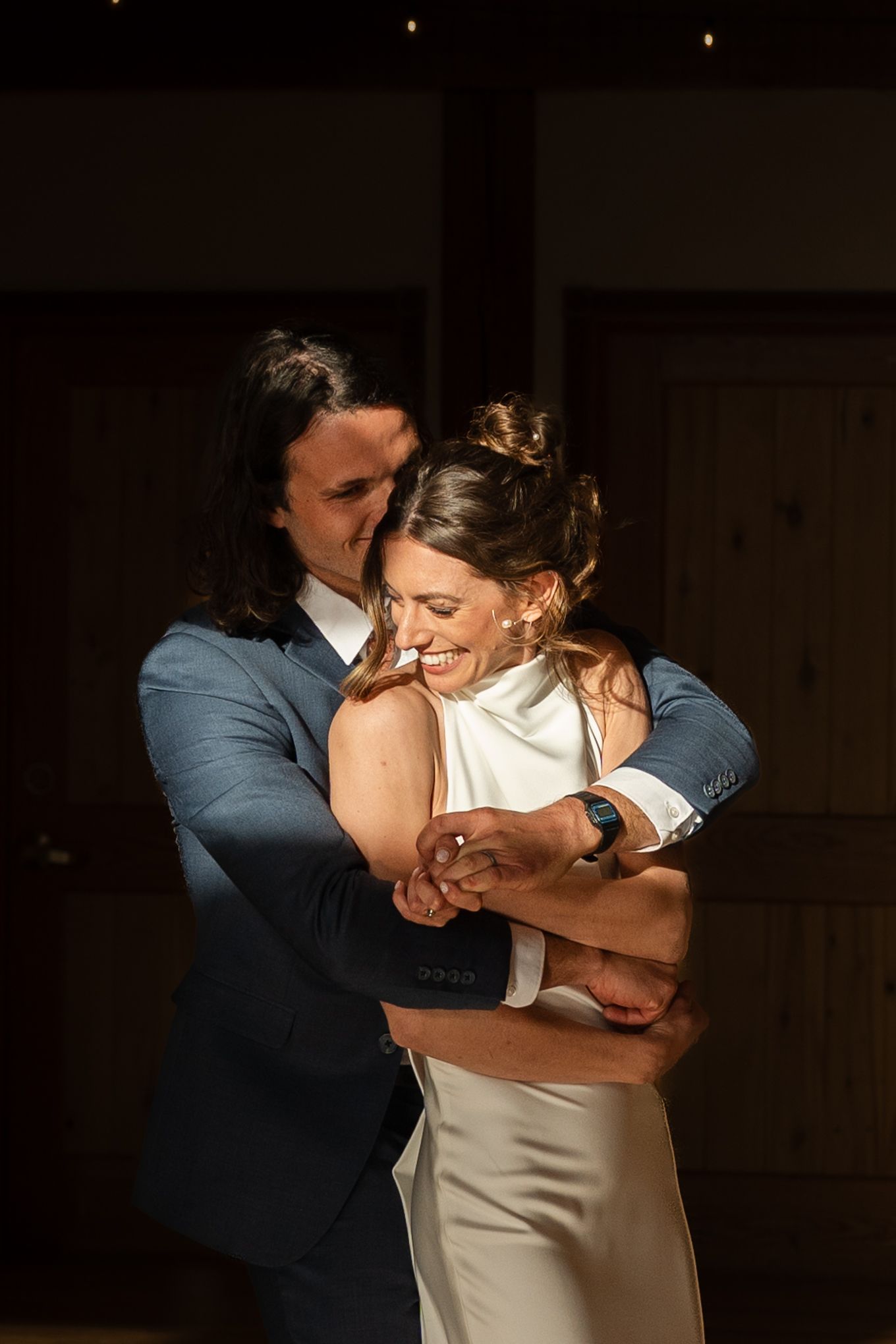 Intimate wedding couple's dance moment captured in warm lighting at an indoor wedding reception.