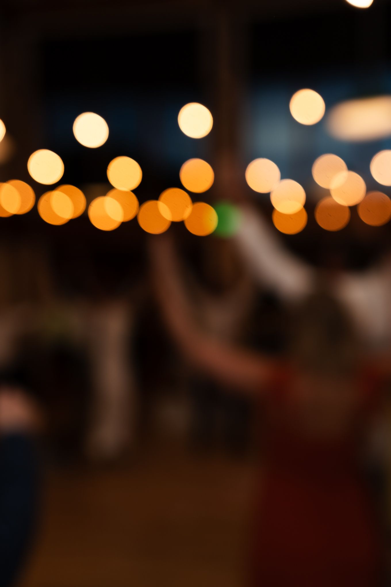 Blurred bokeh lights create a dreamy atmosphere at an evening event.