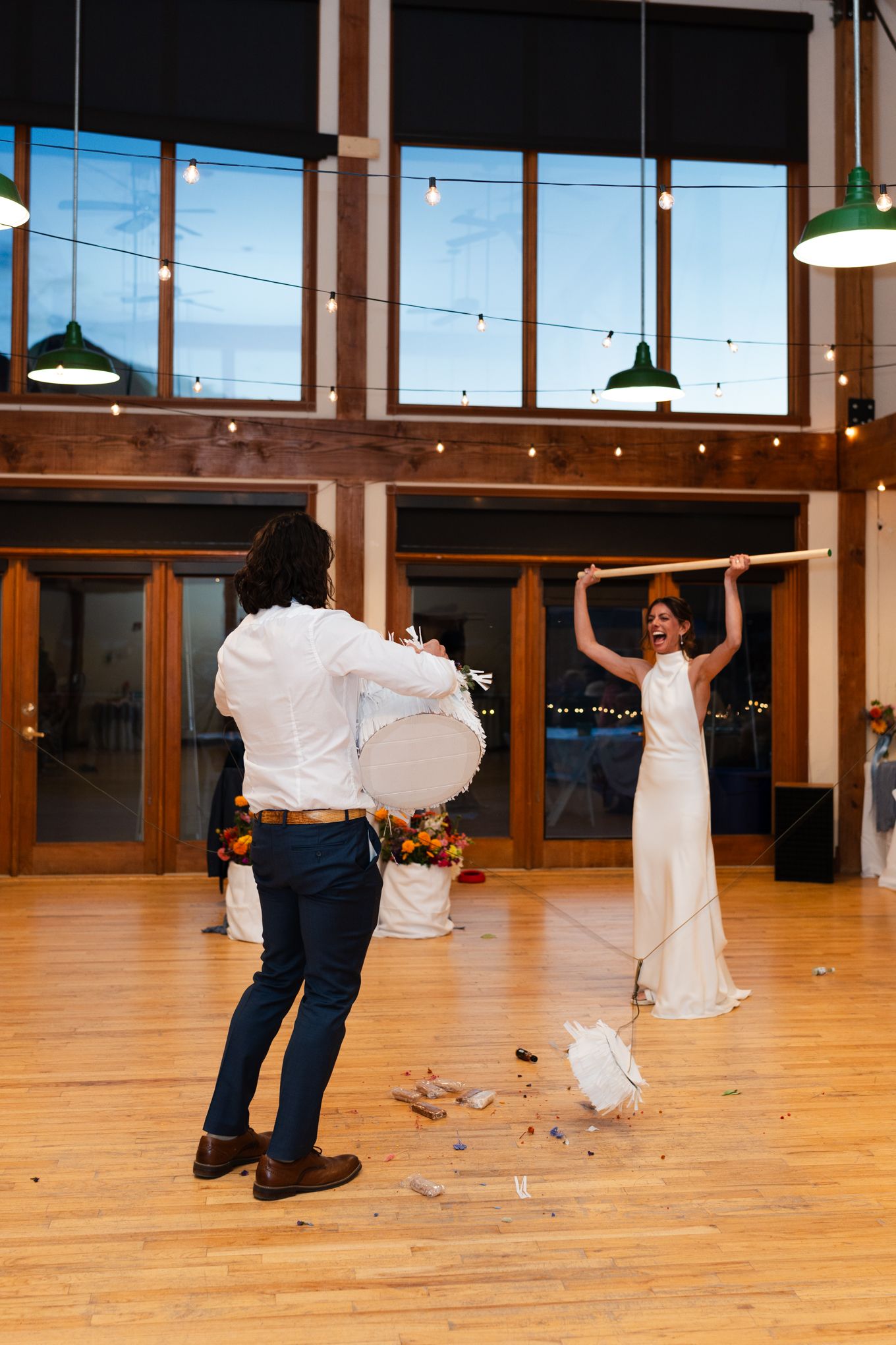 Wedding celebration in a venue with large windows and twinkling lights.