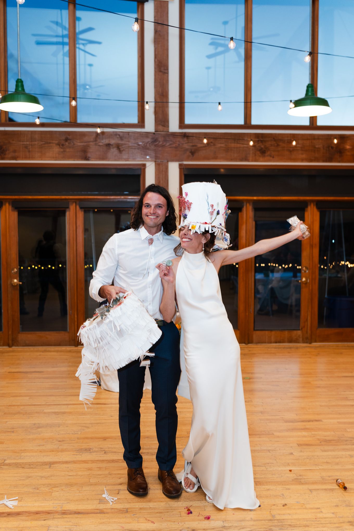Celebratory moment in front of large windows at an evening wedding reception.