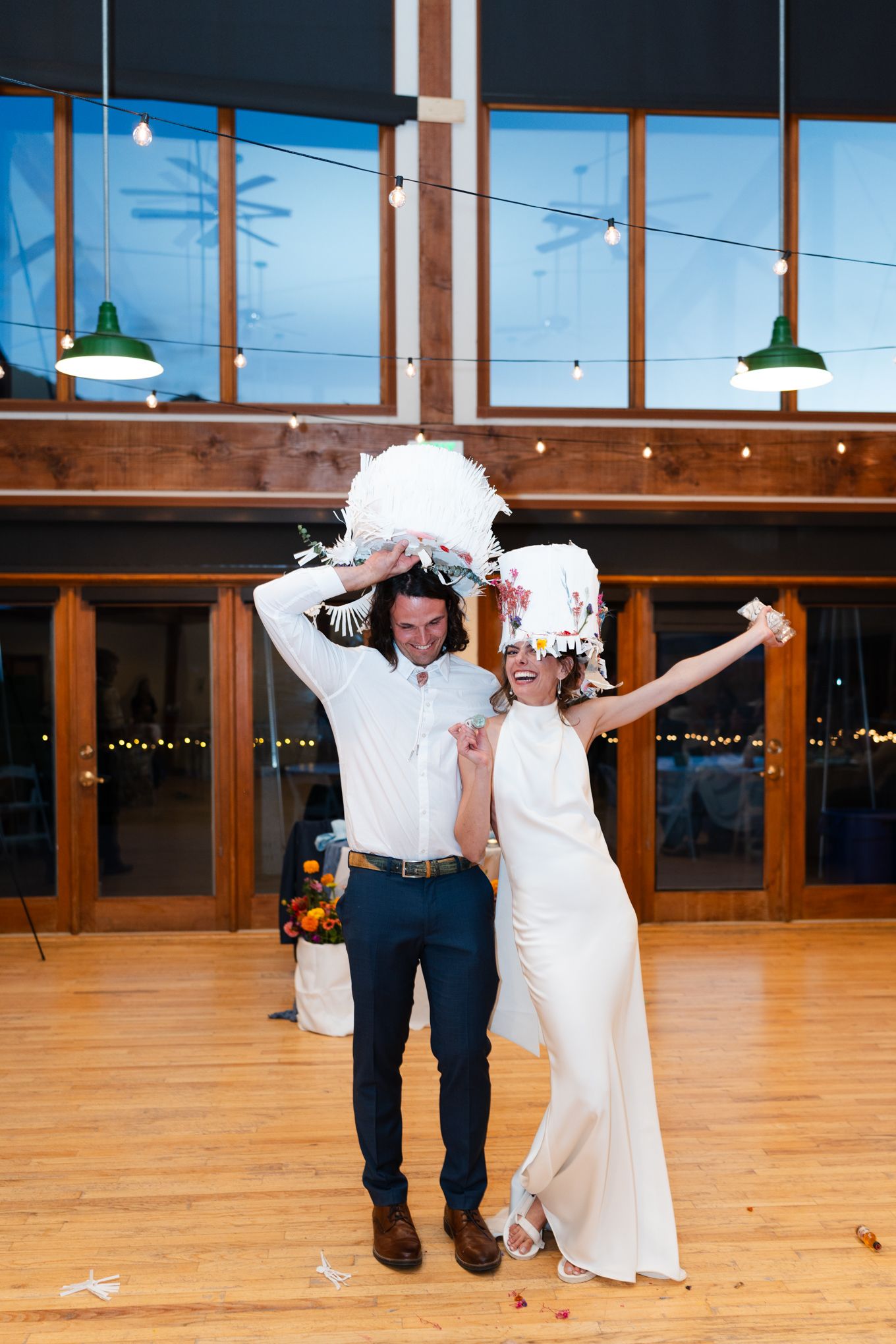 A joyful celebration with white decorations in a rustic venue with wood beams.