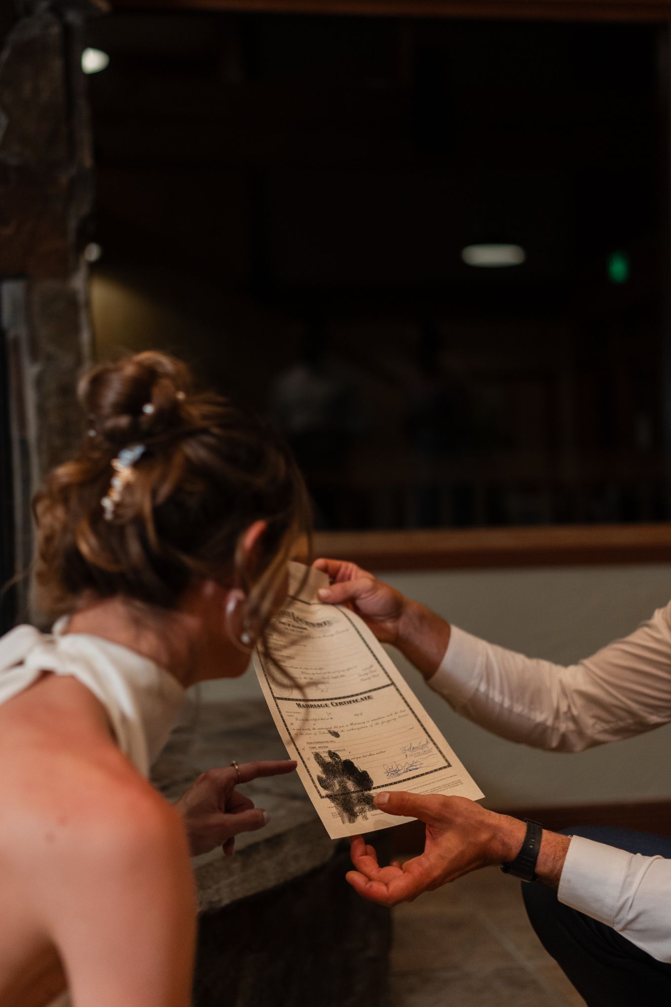 Bride examining their marriage certificate together including a dog paw print.