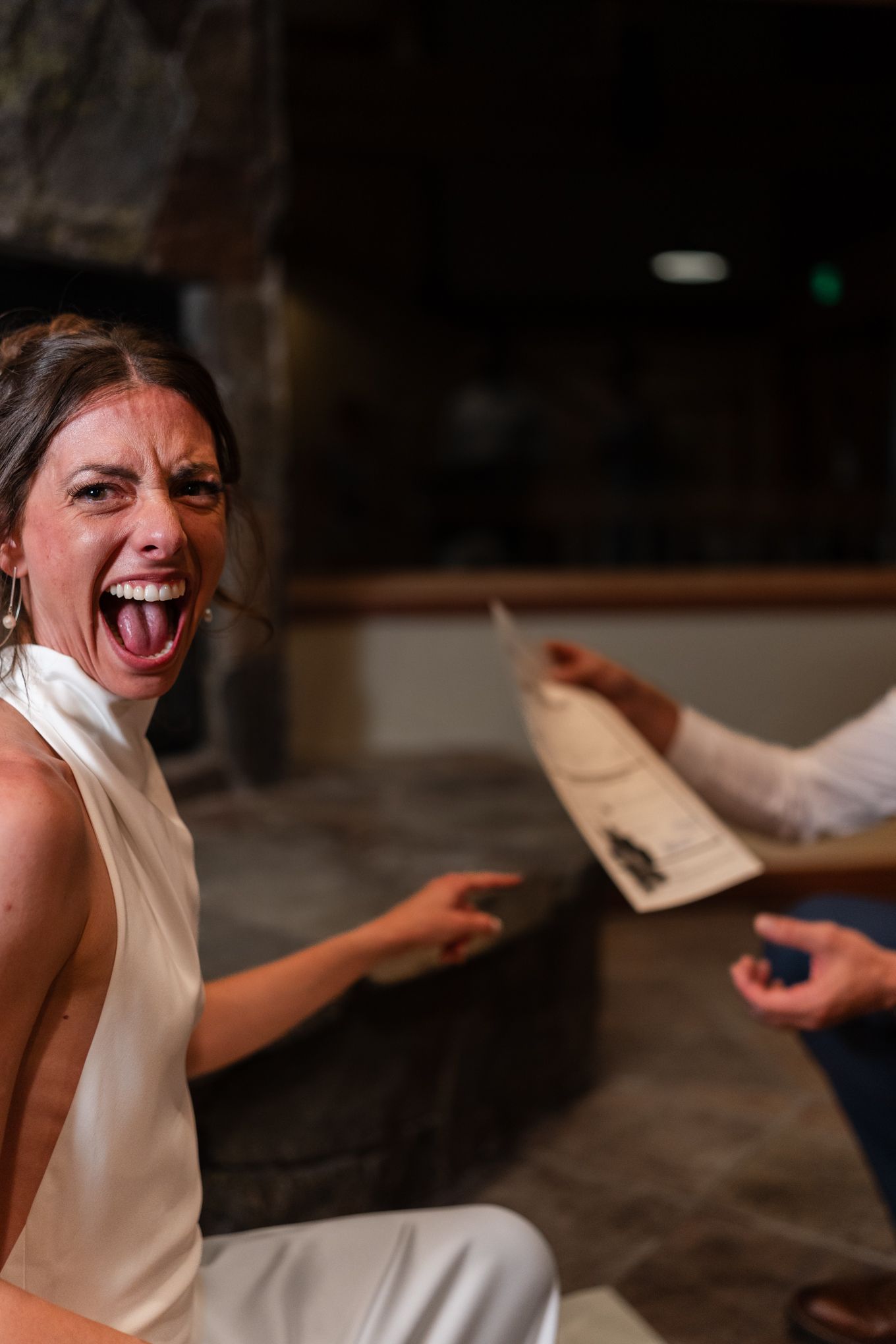 Bride laughing and celebrating a candid moment showing their marriage certificate