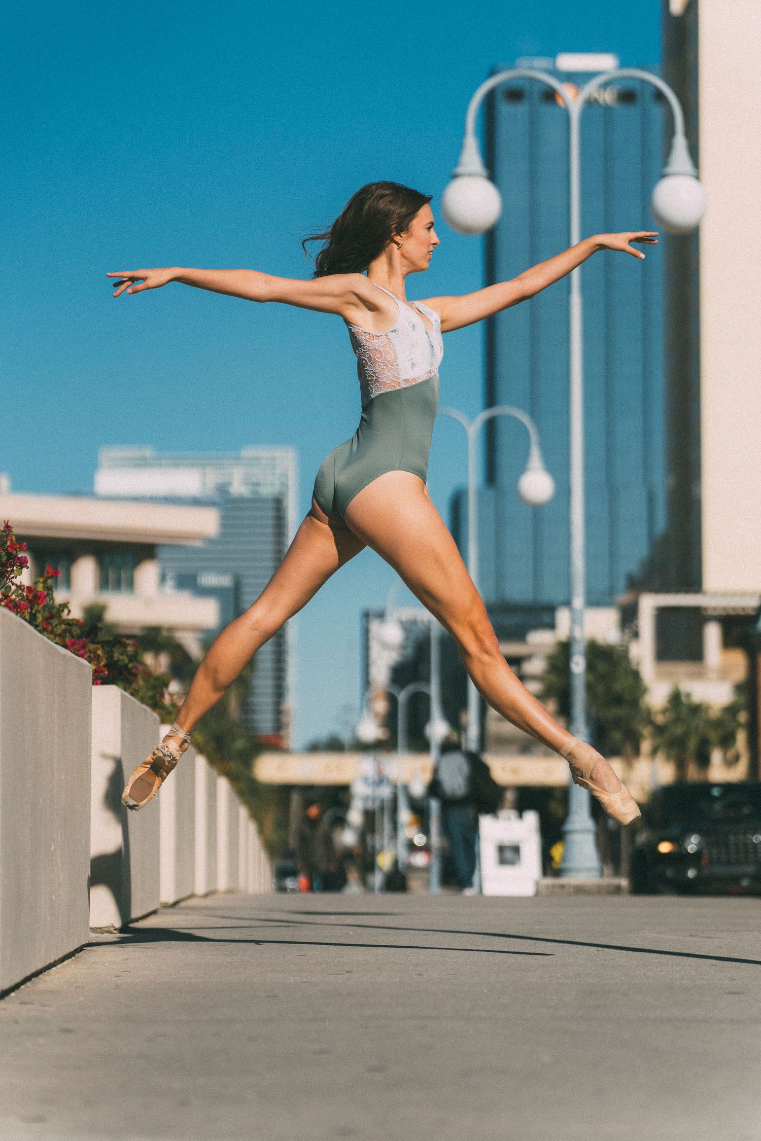 Tampa Florida Ballerina Photoshoot on a bridge while leaping in the air in pointe shoes and leotard.