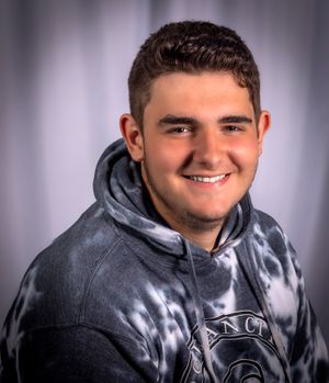 Portrait of person in grey hoodie against studio background.
