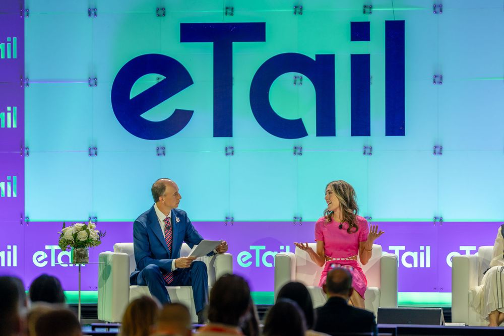 A keynote session at the eTail conference with speakers on stage and blue branding.